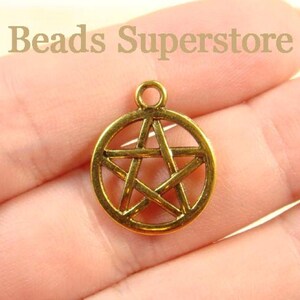 May include: A circular gold-toned metal charm featuring a five-pointed star pentagram design enclosed within a ring, with a small loop at the top for attachment. The text Beads Superstore is visible in the upper portion of the image.