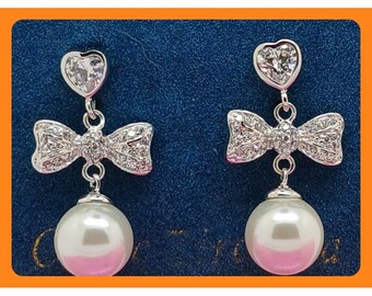 Pendientes colgantes vintage de los años 90 con lazo de perlas y forma de corazón, tono plateado. Raros, nuevos, en su tarjeta original.