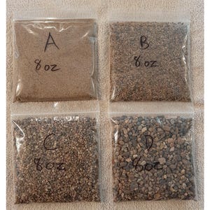 May include: Four clear plastic bags containing different types of sand. Each bag is labeled with a letter A, B, C, and D, and the weight 8 oz.