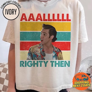 May include: Ivory-colored t-shirt with the text "AAAALLLLL RIGHTY THEN" in red and teal. The shirt features a retro design with a picture of a man in a colorful shirt.