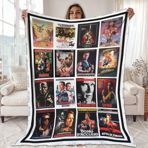 May include: A white blanket featuring a collage of movie posters with Arnold Schwarzenegger. The posters are arranged in a grid and include titles like "Predator", "Commando", and "Last Action Hero". The blanket has a black border.
