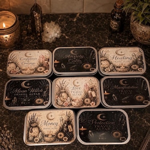 May include: A collection of seven rectangular metal tins, each featuring a unique printed label with celestial and botanical illustrations. The labels include the text: Confidence & Courage, Anxiety & Calm, Healing, Moon Witch, Love, Manifestation, Money, and Protection Travel Altar.