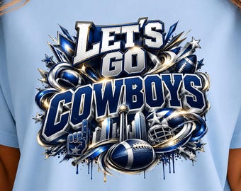 May include: A light blue t-shirt featuring a graphic design with the text LET'S GO COWBOYS in bold white and blue lettering. The illustration includes a football, a helmet, a foam finger, and a city skyline surrounded by stars and swirls.