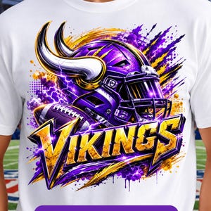 May include: A white t-shirt featuring a graphic of a purple and gold football helmet with horns, a football, and the text VIKINGS in bold yellow letters. The design includes purple and yellow paint splatters, lightning effects, and a purple banner at the bottom with the text INSTANT DOWNLOAD • PNG FILES.