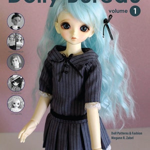 May include: A doll with long, wavy, light blue hair wearing a gray and black striped dress with a white lace trim. The doll is holding her arms out to the side. The book cover reads "Dolly Bureau, volume 1, Doll Patterns & Fashion, Megann R. Zabel".