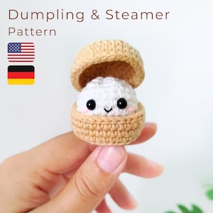 Puede incluir: Un patrón de ganchillo de dumpling y vaporera, con un pequeño dumpling blanco con ojos negros y mejillas rosadas, dentro de una vaporera de color canela de dos piezas. El texto Dumpling & Steamer Pattern aparece sobre el objeto.