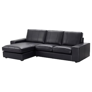 May include: A black leather sectional sofa with a chaise lounge on the left side. The sofa has three seat cushions and a padded armrest on the right. The design is modern and minimalist, with clean lines and a solid, dark color.