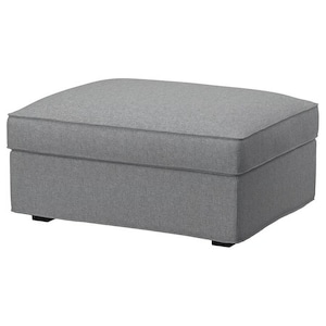 May include: A gray upholstered ottoman with a rectangular shape. The ottoman has a padded top with a contrasting trim and sits on four small black feet. The fabric appears to be a textured weave.