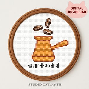 Puede incluir: Un diseño de punto de cruz con una cafetera marrón con granos de café que se elevan por encima, sobre un fondo blanco. El texto "Savor the Ritual" está debajo de la cafetera. El diseño está enmarcado en un aro de madera redondo, con un gráfico rosa en forma de gato "DIGITAL DOWNLOAD".