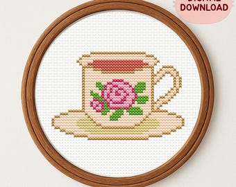 Puede incluir: Diseño de punto de cruz de una taza y un platillo con una rosa rosa y hojas verdes, enmarcado en un aro de madera. El texto "DIGITAL DOWNLOAD" está en una burbuja rosa con forma de gato. El texto "STUDIO CATLANTIS" está en la parte inferior.