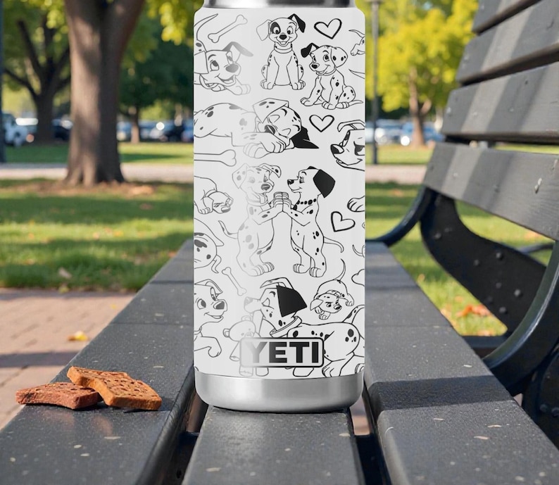 May include: A white YETI tumbler featuring a black and white Dalmatian dog pattern. The design includes various poses of the dogs, bones, and hearts. The tumbler is sitting on a black bench with two brown biscuits.