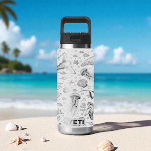 Puede incluir: Una botella de agua blanca con asa y tapa negras, con un patrón repetido de criaturas marinas en blanco y negro. El diseño incluye medusas, estrellas de mar y una manta raya. La botella tiene una base plateada y la marca "YETI" es visible.