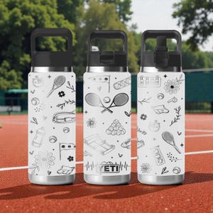 May include: Three white insulated water bottles with black lids and handles, decorated with tennis-themed line art. The designs include tennis rackets, balls, flowers, and other sports-related graphics. The bottles are on a red surface.