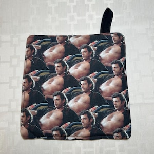 May include: Square black and white pot holder with a repeating pattern of a shirtless man. The pot holder has a black loop for hanging. The image on the pot holder is a collage of the same man.