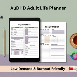 Op de afbeelding: Een AuDHD Adult Life Planner wordt weergegeven op een tablet, met een pen en een afgedrukte Energy Tracker. Een kopje thee, een onderzetter en een kleurrijk speeltje zijn ook aanwezig. De tekst luidt "Low Demand & Burnout Friendly."