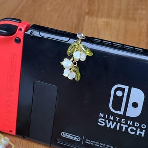 May include: A white ceramic mug with a black handle and the text "But First, Coffee" in a bold, black font. The mug is set against a neutral background, highlighting its simple design.