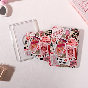 Könnte beinhalten: Eine transparente Tablet-Hülle mit einer Collage aus Aufklebern in Rosa, Rot und Leopardenmuster. Der Text umfasst "I'd rather be reading", "Book addict", "One more chapter", "Slow burn", "Busy woman", "Do it for the plot" und "Main character".