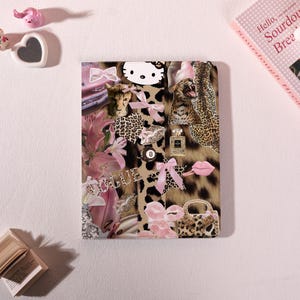 May include: A collage featuring a leopard print background with pink accents. Elements include a Hello Kitty face, pink bows, a perfume bottle, pink lips, a small purse, and the word "VOGUE". The collage has a feminine and fashionable theme.