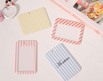 May include: A collection of striped name tags in various colors: yellow, red, pink, and blue. One tag has the name "Monteiro" printed on it. A decorative box with the words "Hello, Sourdough Bread" is also visible.