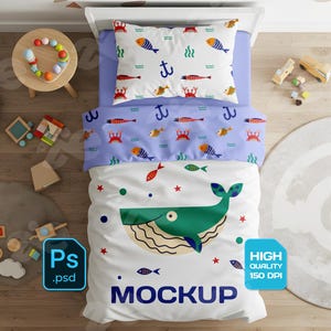 May include: A children's bed set with a whale design. The set includes a pillow, a duvet cover, and a sheet, all featuring marine life illustrations. The word "MOCKUP" is printed on the sheet. The set is on a white bed.