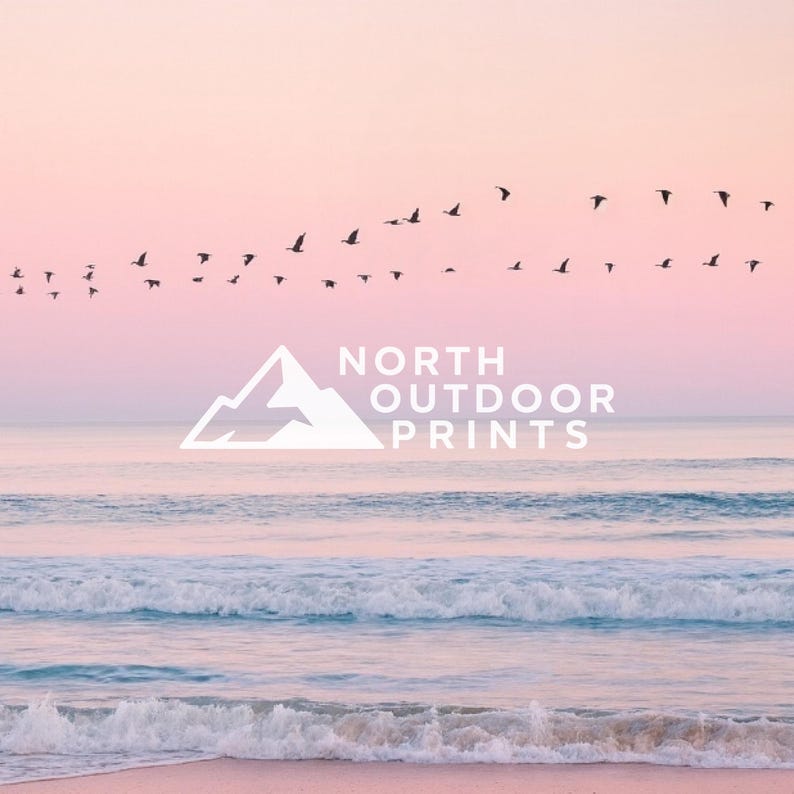 May include: A serene coastal scene with a pink and peach sky, gentle waves, and a sandy beach. Silhouetted birds fly across the sky. The white logo for "NORTH OUTDOOR PRINTS" is centered in the image.