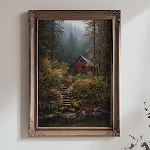 Puede incluir: Una pintura enmarcada representa una cabaña roja en un bosque exuberante. La cabaña está rodeada de árboles y follaje verdes, con una escalera de piedra que conduce a ella. La obra de arte está encerrada en un marco de madera marrón y ornamentado, creando una estética rústica.