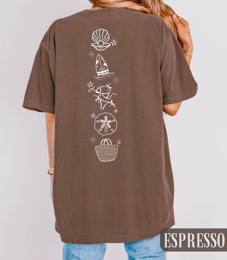 May include: Espresso-colored t-shirt with a vertical white graphic of beach-themed illustrations, including a seashell, surfboard, bikini, sand dollar, and tote bag. The word "ESPRESSO" is printed in a white rectangular box at the bottom.