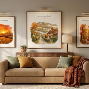Può includere: Un divano beige testurizzato con due cuscini verde oliva, un cuscino giallo senape e una coperta in maglia color ruggine. Sopra il divano ci sono tre stampe paesaggistiche incorniciate con scene autunnali e il testo Autumn's slow breath.