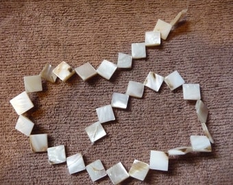 Beads, Mother of Pearl, 14-15mm Flat Diamond, Natural Bleached/White. Sold per 15-inch strand. There are 30 beads on the strand.