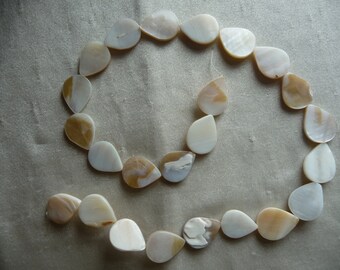 Beads, Mother of Pearl, 18x12mm Flat Teardrop, Natural Bleached/White. Sold per 15-inch strand.  There are 24 beads on the strand.