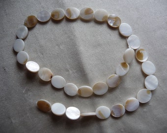 Beads, Mother of Pearl, 14x10mm Flat Oval, White/Natural Bleached. Sold per 16-inch strand. There are 32 beads on the strand.