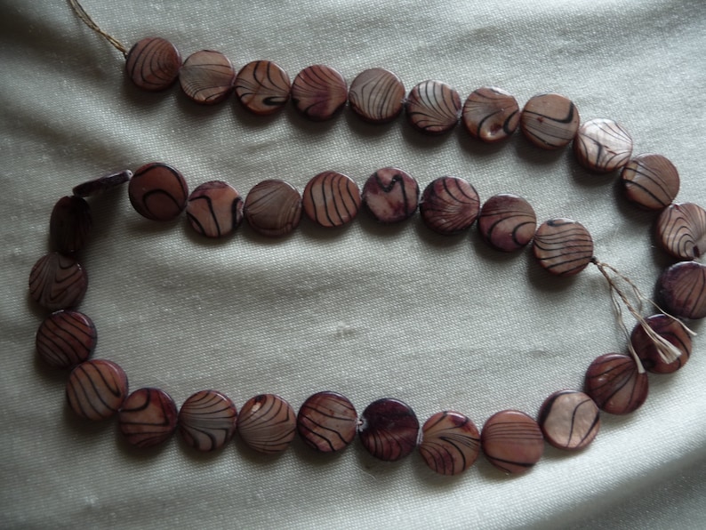 Sold per 16 inch strands. Shades of Brown with Black Stripe Design 2 Strands of Mother of Pearl 12mm Flat Round Coin