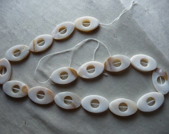 Beads, Mother of Pearl, 25x16mm Open Oval, White/Beige. Sold per 16 inch strand. There are 16 beads on the strand.