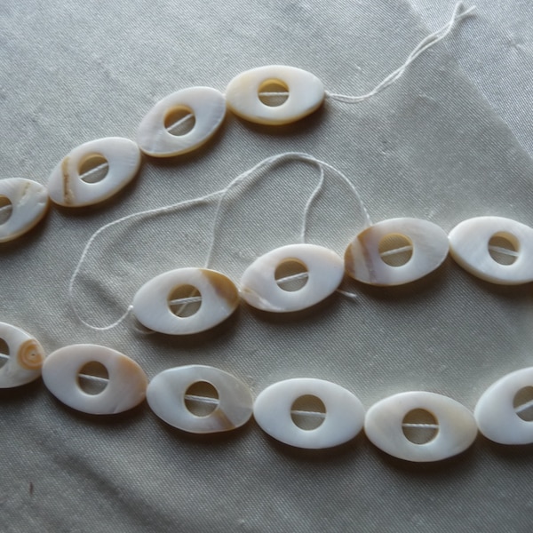 Beads, Mother of Pearl, 25x16mm Open Oval, White/Beige. Sold per 16 inch strand. There are 16 beads on the strand.