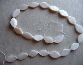 Beads, Mother of Pearl, Natural Bleached/White, 20x10-16x10mm Flat Oval. Sold per 15 inch strand. There are 22 beads on the strand.