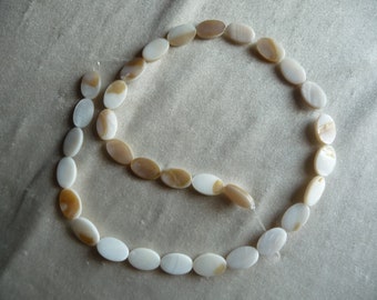 Beads, Mother of Pearl, 12x8mm Flat Oval, White/Natural Bleached. Sold per 16-inch strand. There are 31 beads on the strand.