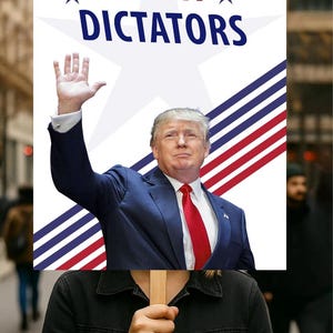 May include: A protest sign with the words "NOT MY DICTATORS" in red and blue. The sign features an image of a man in a suit and red tie, with his right hand raised. The sign is held by a person in a black jacket.