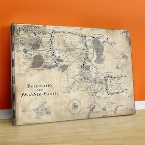 Può includere: Stampa su tela di una mappa di Beleriand e della Terra di Mezzo. La mappa è in bianco e nero, con dettagli intricati di montagne, fiumi e luoghi. Il testo "Beleriand and Middle-Earth" è scritto in un font stilizzato. La tela è rettangolare.
