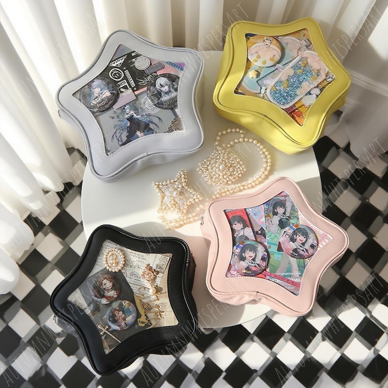 Puede incluir: Cuatro bolsas en forma de estrella en gris, amarillo, negro y rosa, cada una con una ventana transparente que muestra varios art&iacute;culos como pines y tarjetas. Tambi&eacute;n hay un collar de perlas y joyas en forma de estrella. Las bolsas est&aacute;n sobre una superficie blanca con un suelo a cuadros blanco y negro.