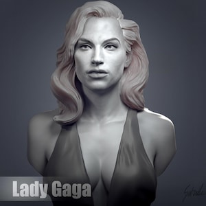 Könnte beinhalten: Eine weiße Büste einer Frau mit blonden, wellenförmigen Haaren. Sie trägt ein ärmelloses Kleid mit tiefem V-Ausschnitt. Die Skulptur trägt den Titel "Lady Gaga".