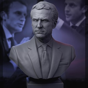May include: A gray bust sculpture of a man wearing a suit and tie. The bust is on a black base.