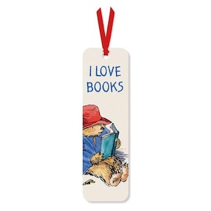 May include: A rectangular bookmark with a red ribbon. The bookmark features a watercolour illustration of a bear wearing a red hat and blue coat, reading a book. The text "I LOVE BOOKS" is printed at the top.