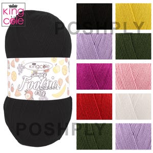 Może przedstawiać: Duża czarna kulka przędzy z kolorową etykietą z ilustracjami owoców. Na etykiecie widnieje napis "King Cole Simply Footie 4 Ply". Dodatkowe kolory przędzy są wyświetlane w tle, w tym czarny, żółty, fioletowy, zielony, różowy, czerwony i biały.