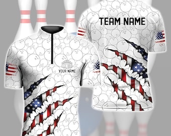 May include: White bowling shirt with a pattern of bowling balls and the American flag design. The shirt has a black collar and a zipper. The text "YOUR NAME" and "TEAM NAME" are visible on the shirt.