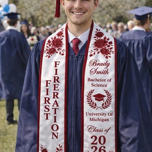 A smiling young man in a graduation gown and cap, with a personalized sash that reads "Brady Smith Bachelors of Science University of Michigan Class of 2016".