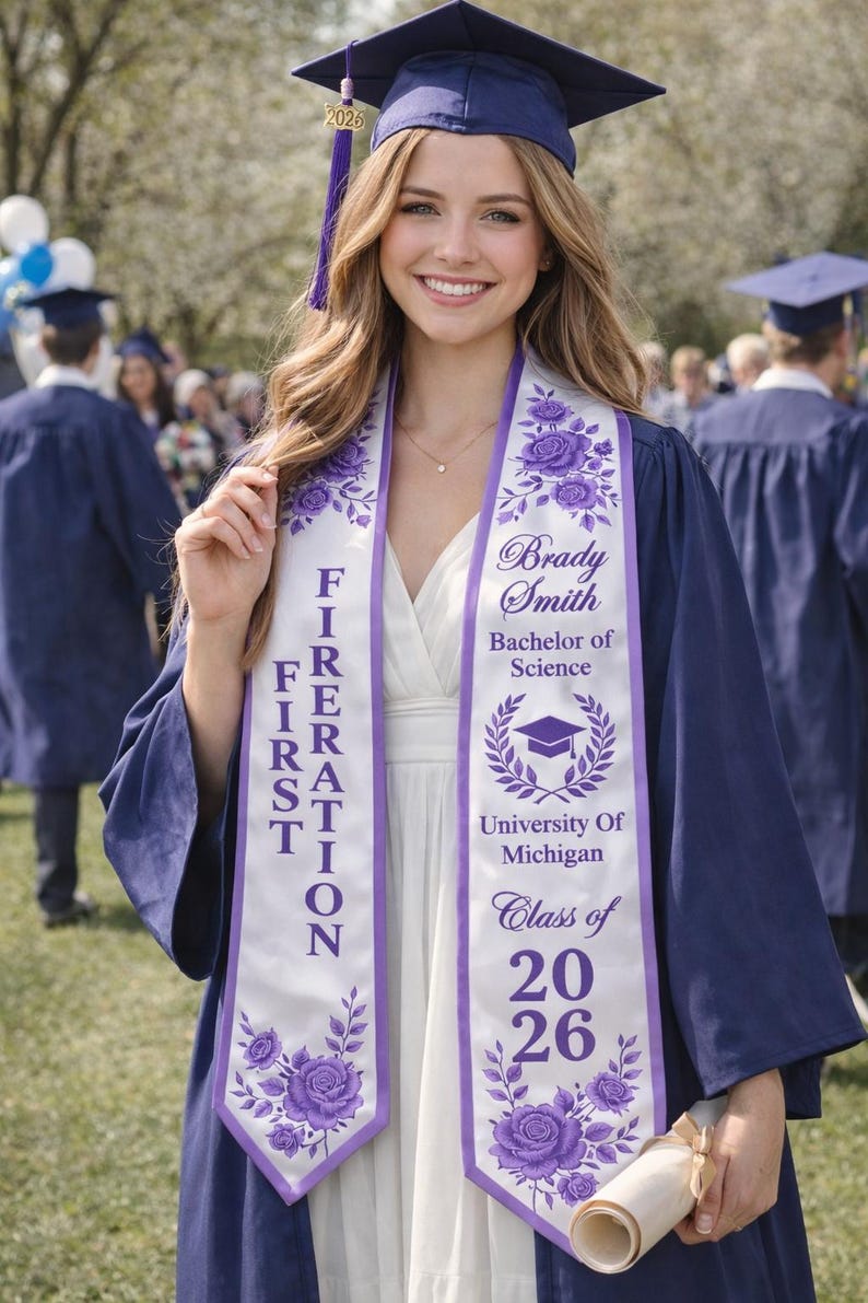 A smiling young woman in a graduation gown and cap stands in front of a crowd, holding a diploma.