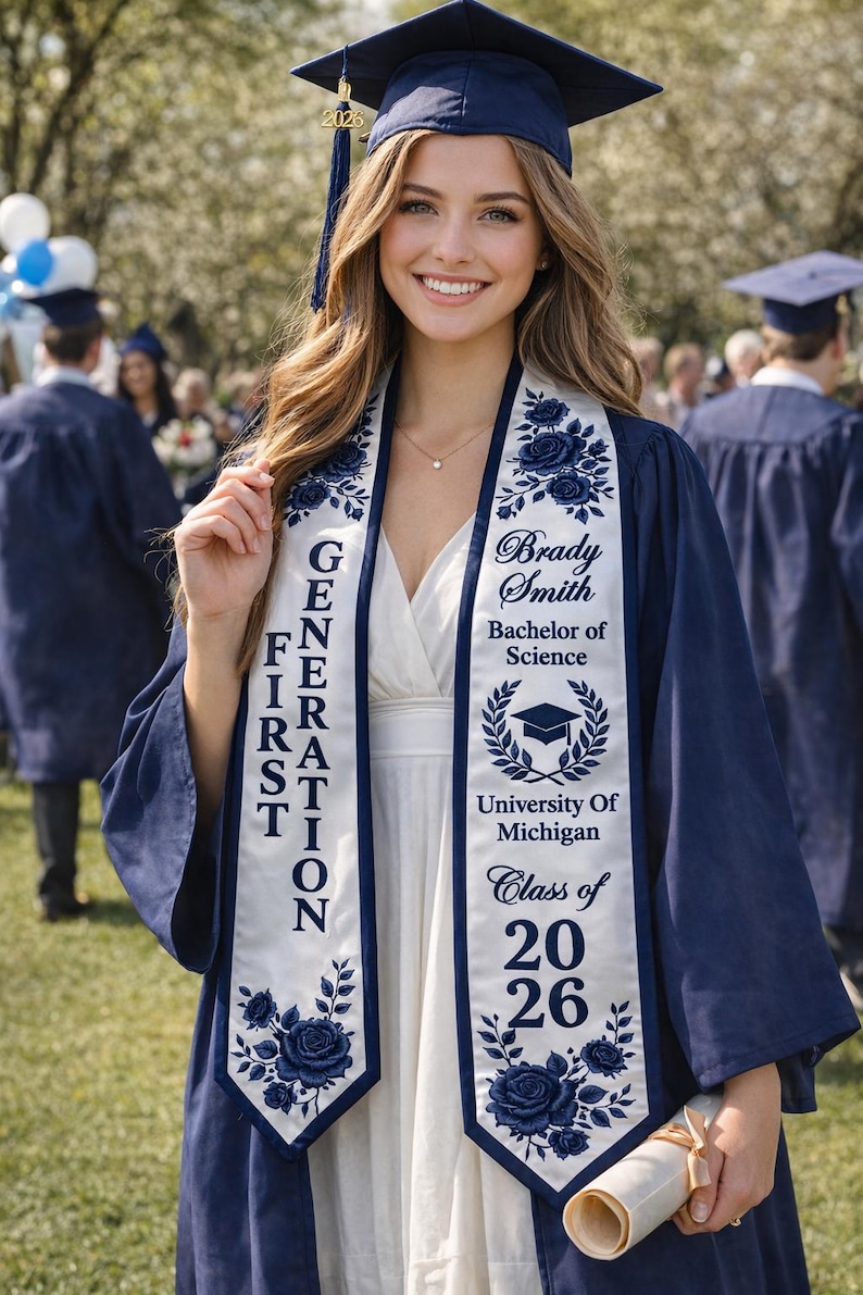 A smiling young woman in a blue graduation gown and cap stands in front of a crowd at a graduation ceremony.