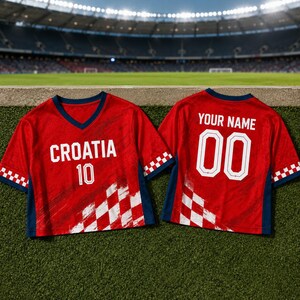 A red Croatia soccer jersey with the number 10 and the name "YOUR NAME" printed on the back, displayed on a grassy field with a stadium in the background.