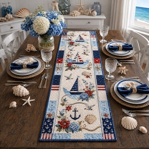 May include: A rectangular quilted table runner featuring a nautical theme with sailboats, anchors, seashells, and floral accents in shades of blue, red, and white. The runner has a border of navy blue and white stripes and small anchor patterns.