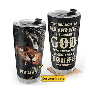 Peut inclure: Deux gobelets de voyage noirs en acier inoxydable. L'un présente un lion et le visage d'un homme, avec le nom "WILLIAM". L'autre gobelet porte le texte "THE REASON I'M OLD AND WISE IS BECAUSE GOD PROTECTED ME WHEN I WAS YOUNG AND STUPID."